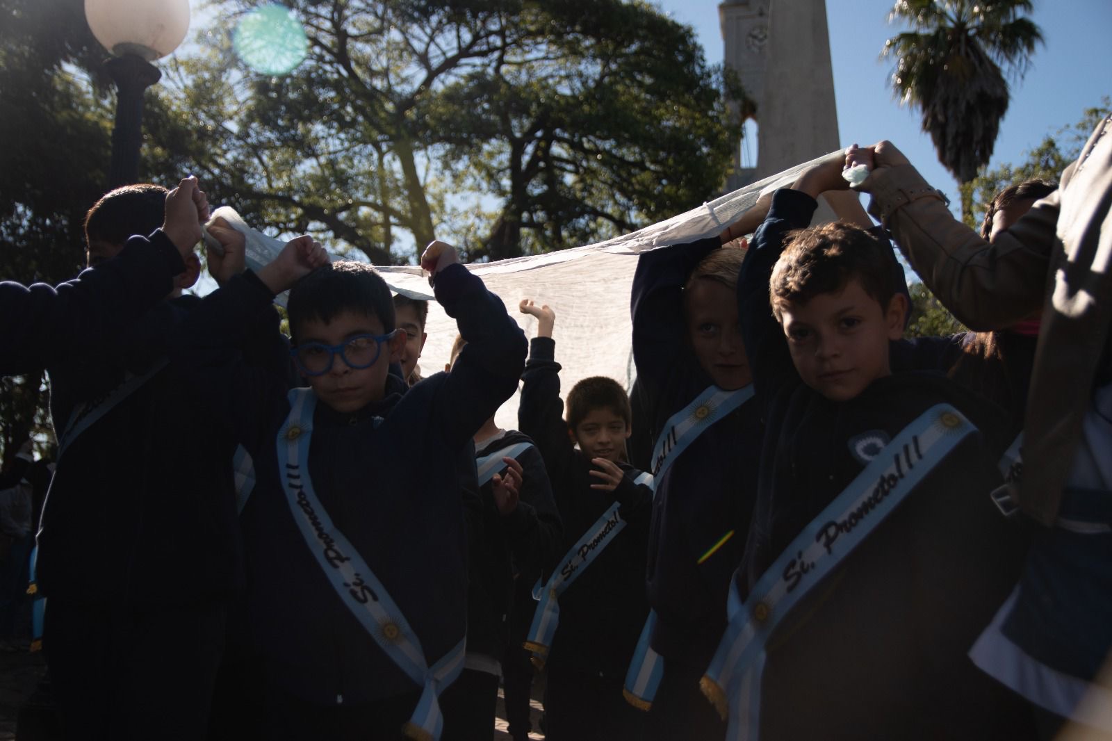 Alumnos de 4° grado ingresan portando la Bandera Argentina más larga de Roldán durante el acto